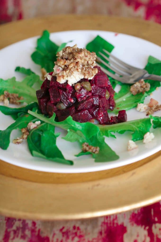 beet tartare topped with tofu chevre on a white plate