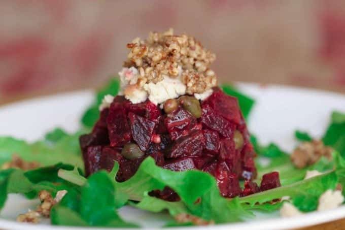 Beet Tartare topped with garlic tofu chevre on a white plate