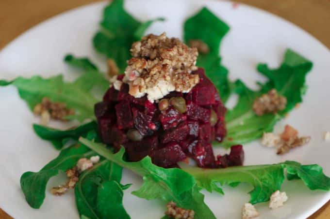 Beet Tartare side view on a white plate topped with tofu chevre