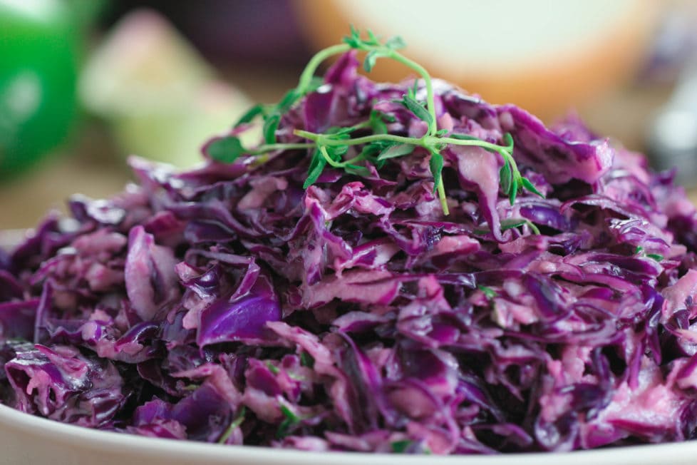 A close up of a purple cabbage slaw on a white plate