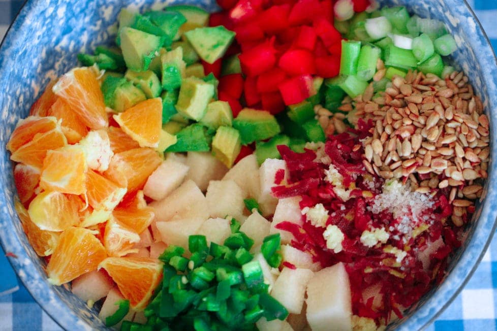 A blue bowl filled with fresh vegetables for salad