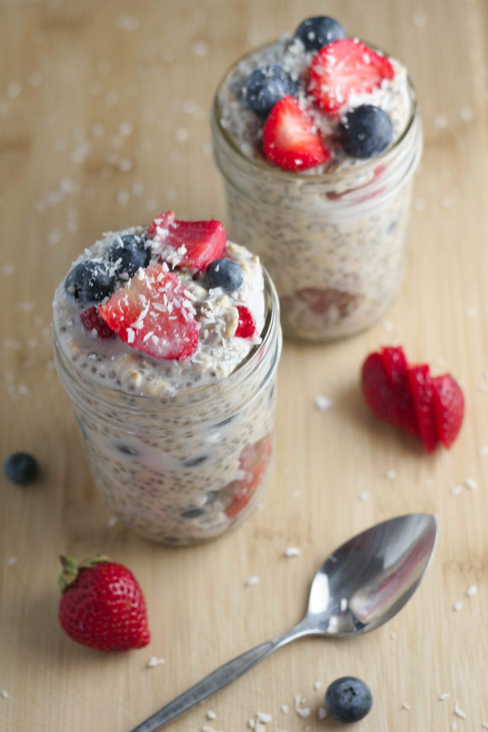 An overhead shot of overnight oats with berries and coconut sprinkles
