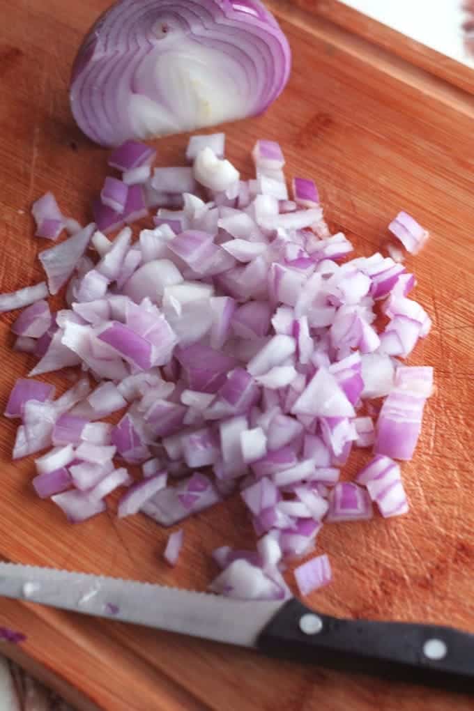 diced red onion on a wood cutting board