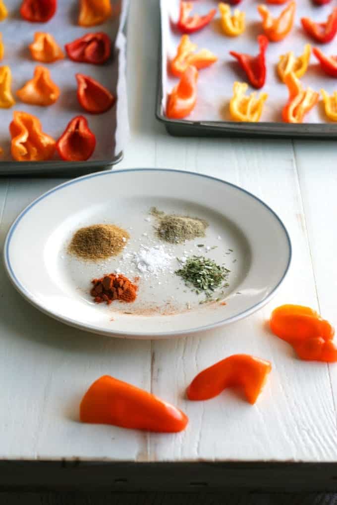 A plate of spices to make stuffed mini peppers that are on trays in background