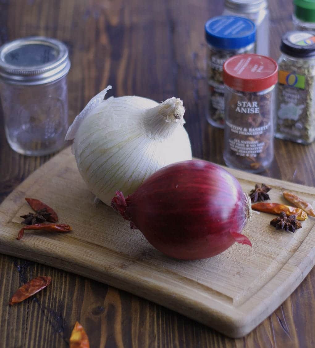 Ingredients for two toned pickled onions on a wooden cutting board