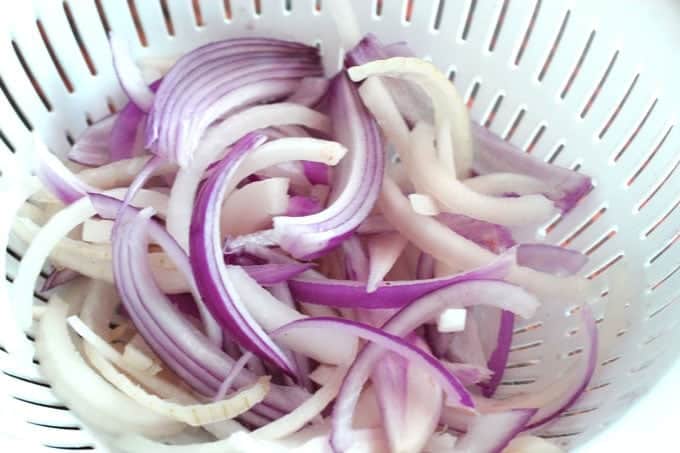 red and white onions in a colander 