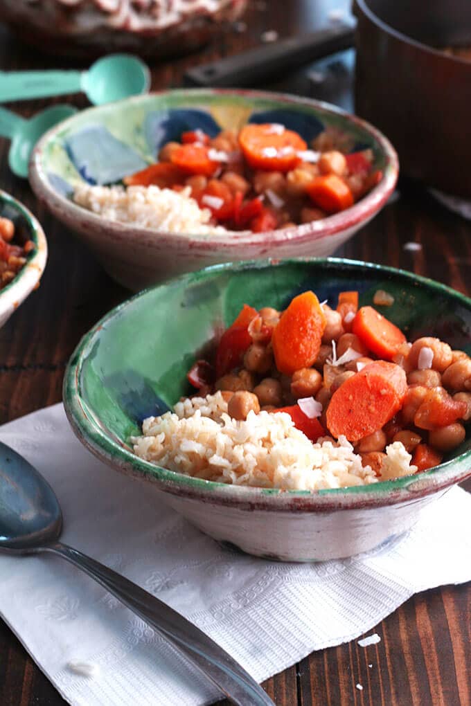 two bowls of stew and rice on a table