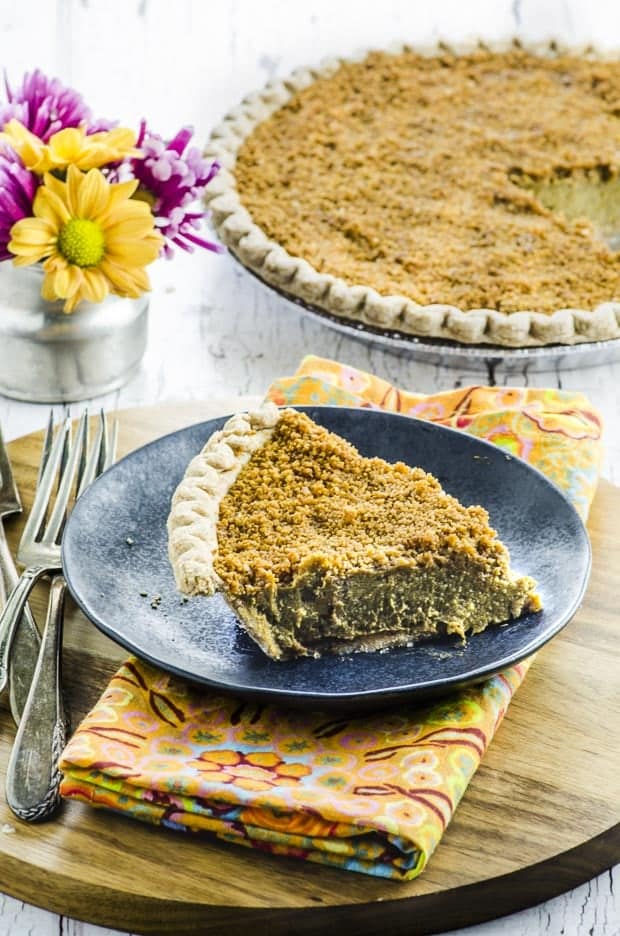 A slice of pumpkin pie sitting on top of a wooden table