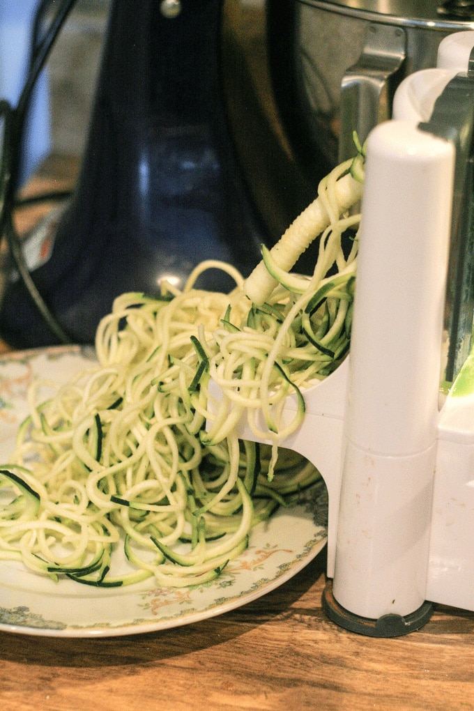 A close up of a zucchini being spiralized on a table