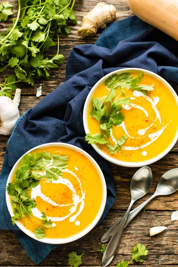 2 bowls of Butternut Squash Soup on a wood table