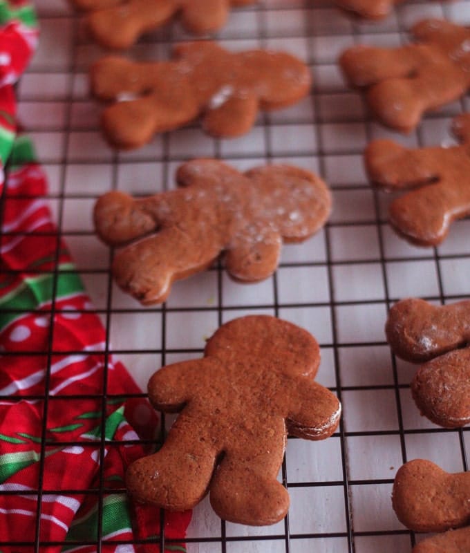 A group of gingerbread men on a cooling rack before being decorated