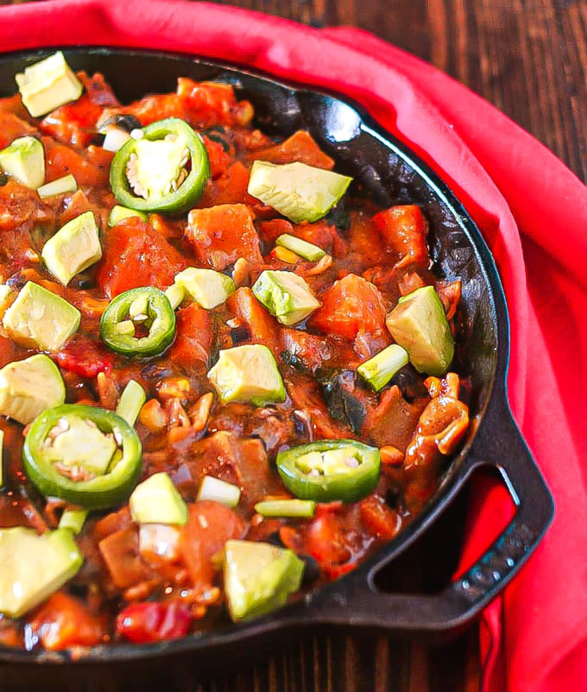 overhead closeup shot of vegan enchiladas in cast iron skillet 