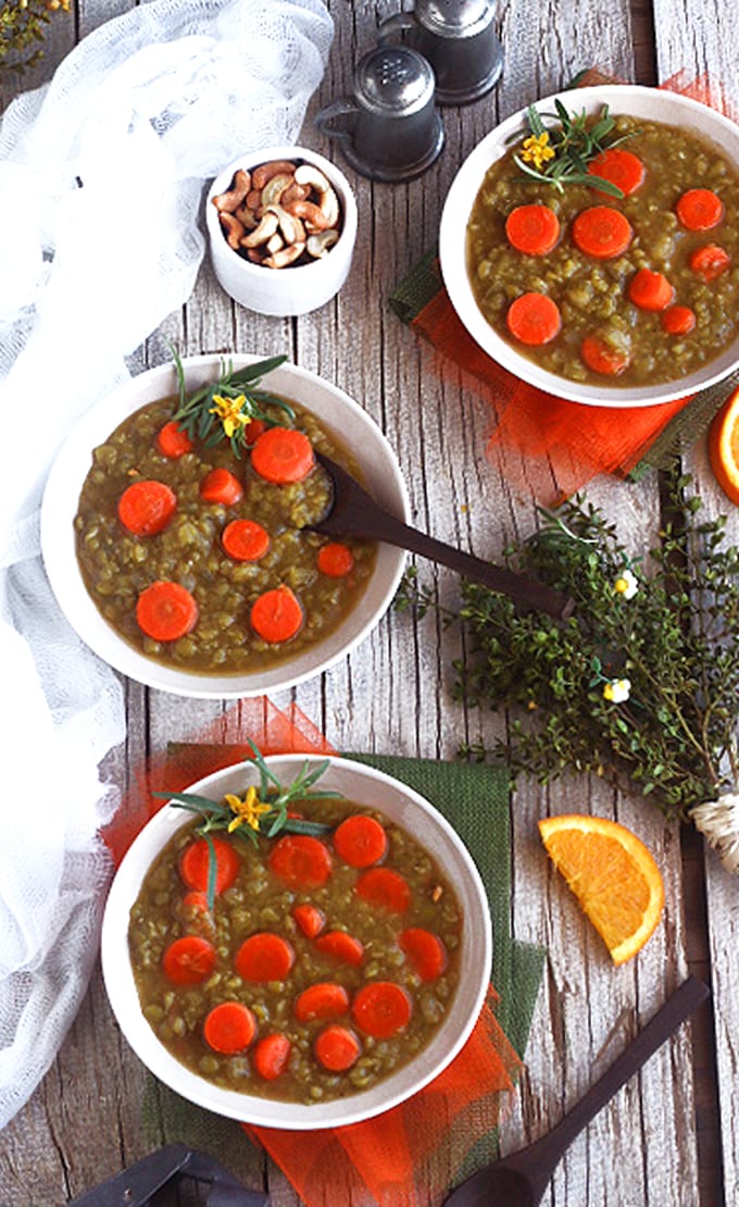three bowls of split pea soup on a wooden table