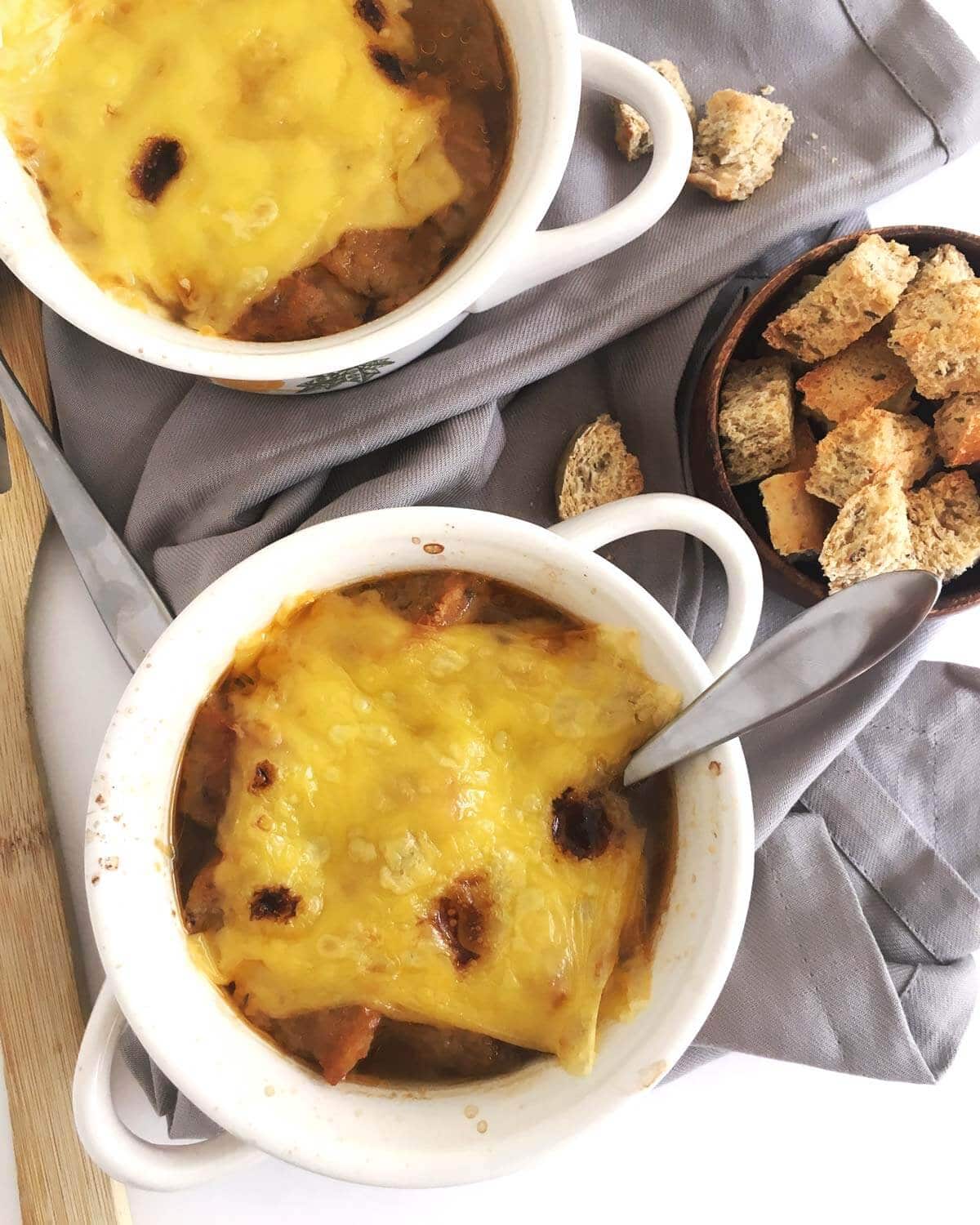 An overhead shot of french onion soup in two bowls