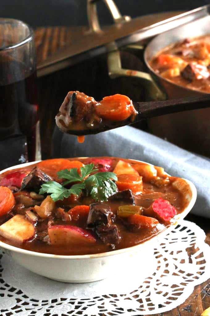 A person\'s showing a bite full of stew on a spoon 