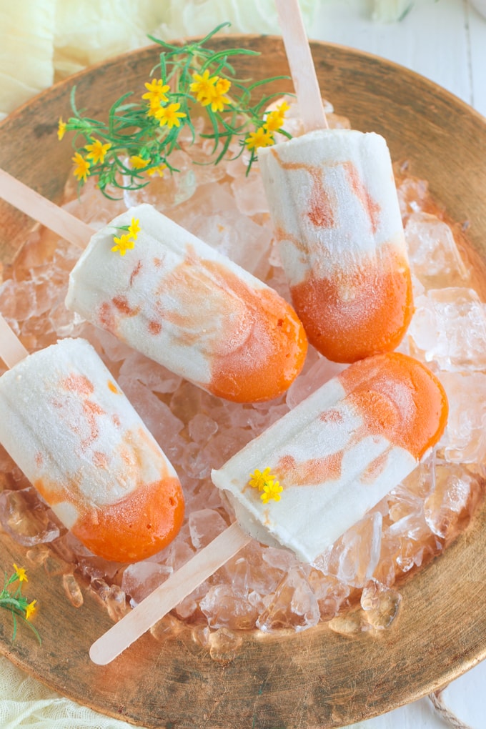 plate of popsicles on ice topped with yellow flowers