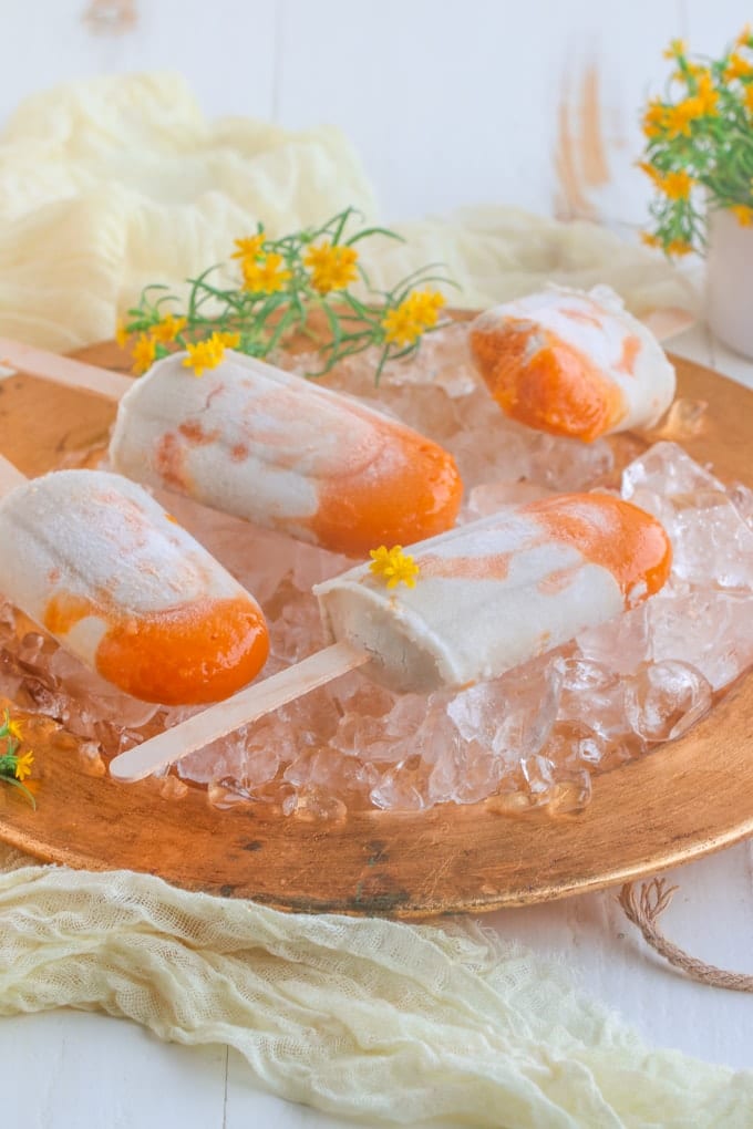 A gold plate of popsicles on ice