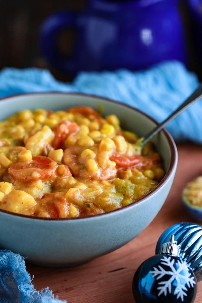 A side view of bowl of soup in a blue bowl with Corn chowder and Comfort food