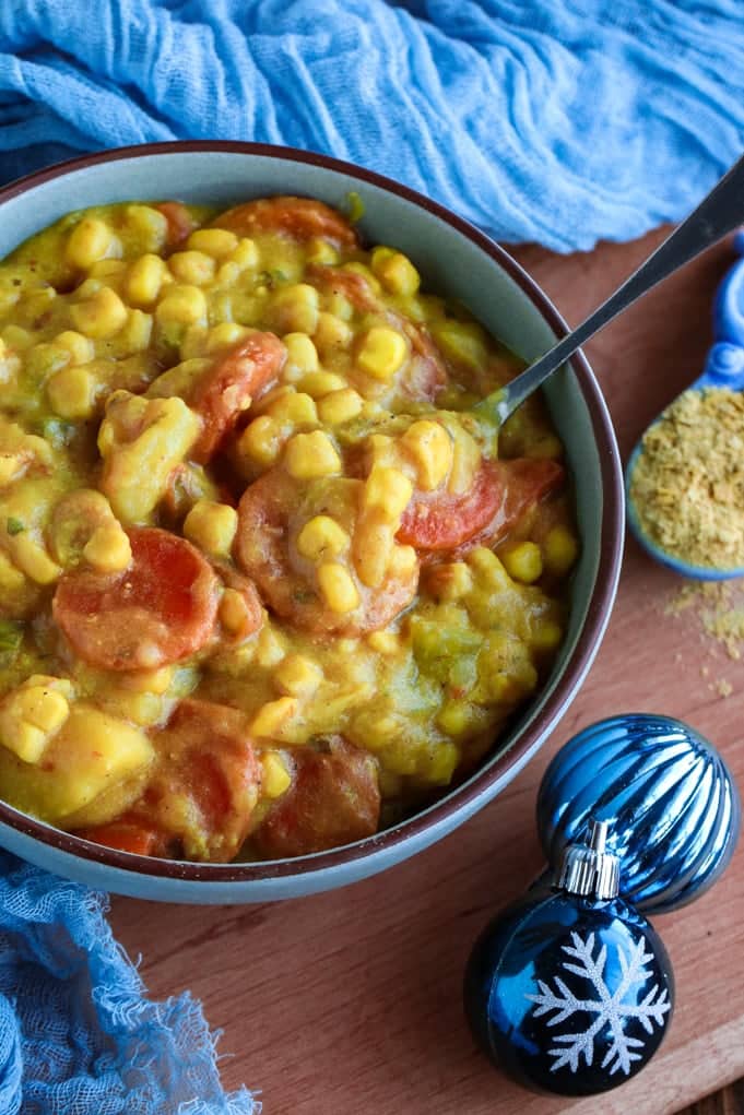 A blue bowl of corn soup on a table