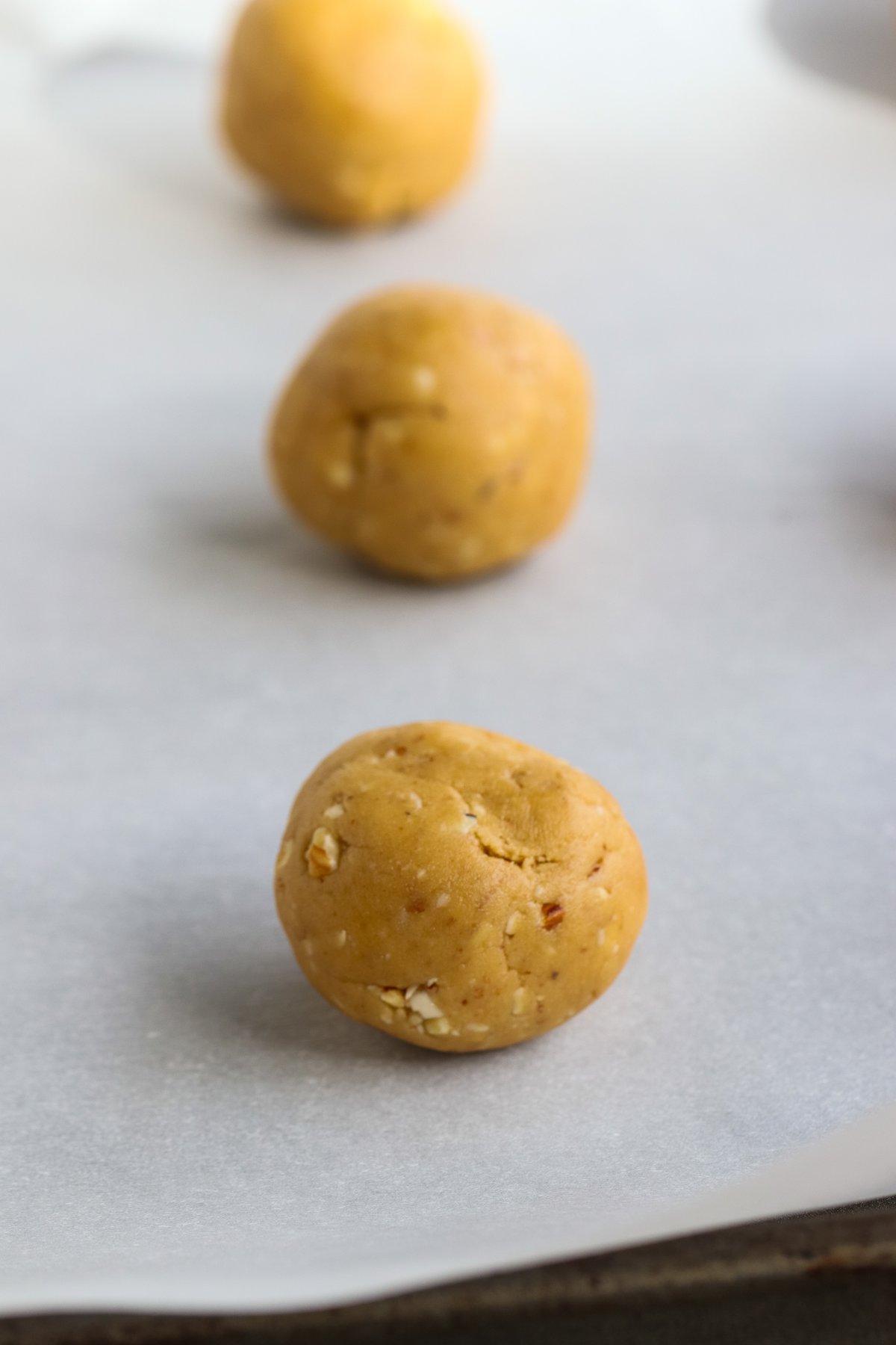 raw vegan almond balls on a cookie sheet