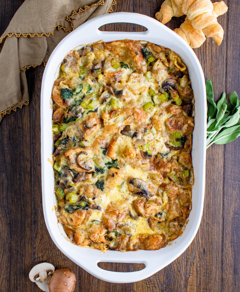 vegan croissant stuffing in white casserole dish on a wooden table