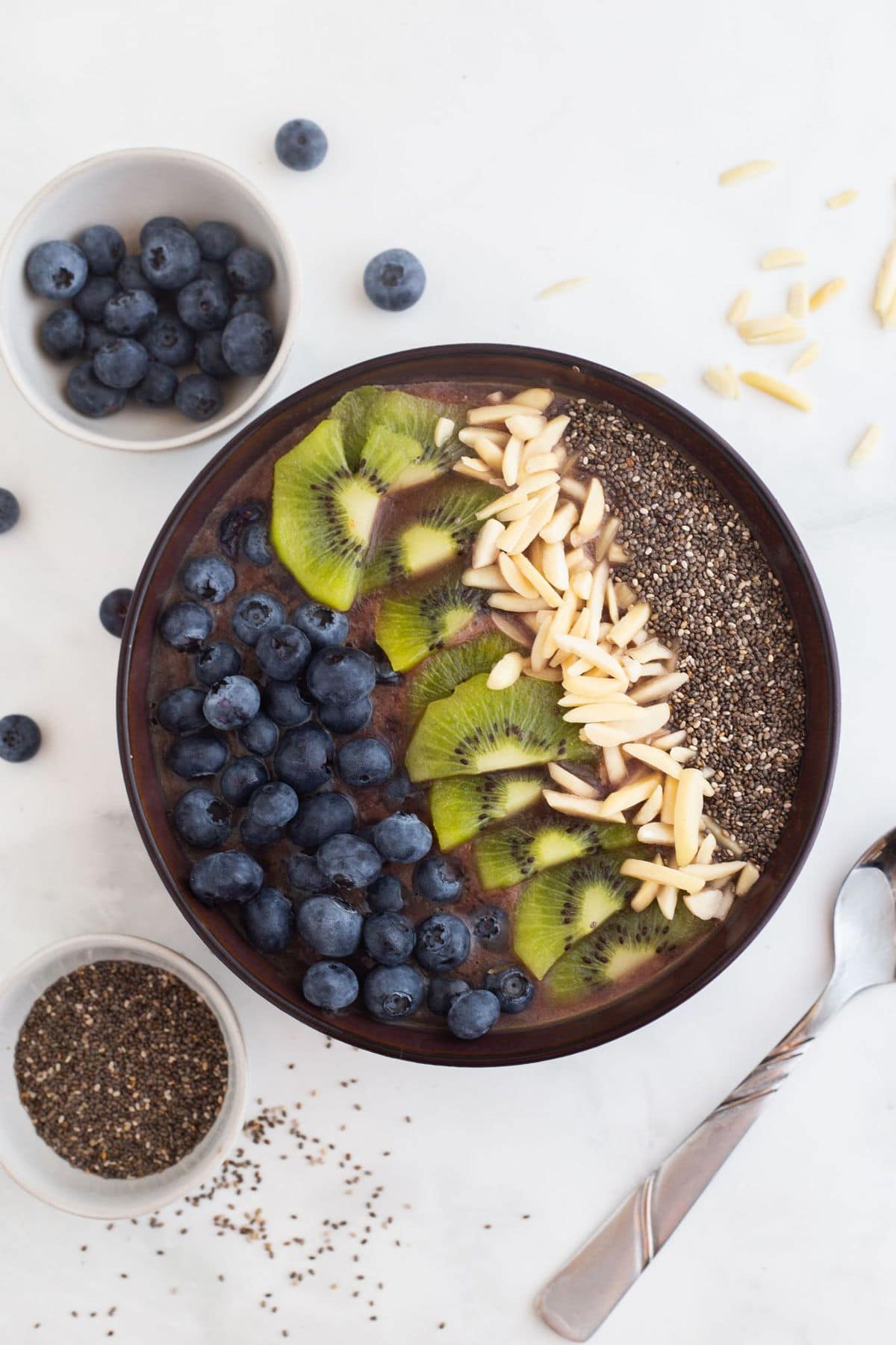 overhead shot of acai smoothie bowl on a white table