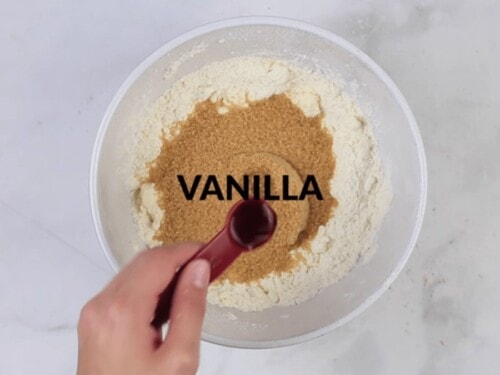 vanilla being added to a white bowl to make cookie dough