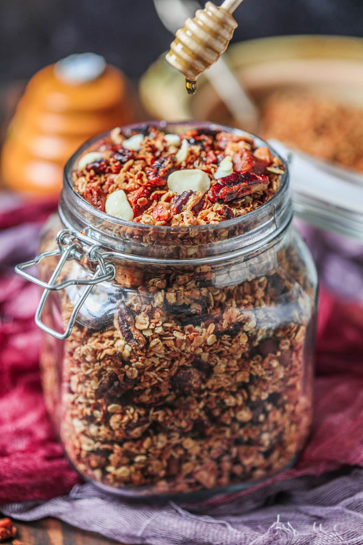jar of granola with maple syrup dripping over it