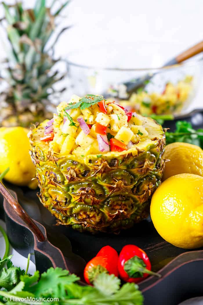 pineapple salsa in an actual pineapple surrounded by garnishes. 