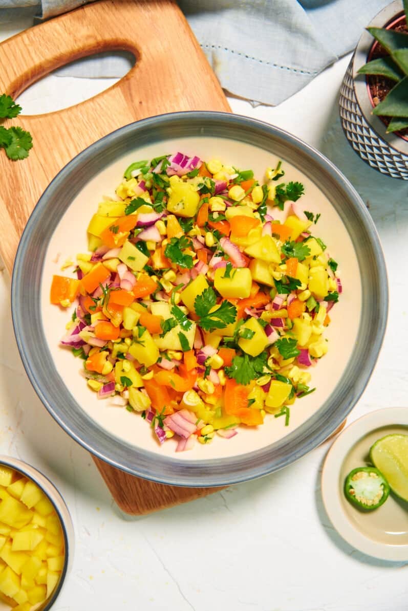 overhead view of mango salsa in a bowl on a cutting board