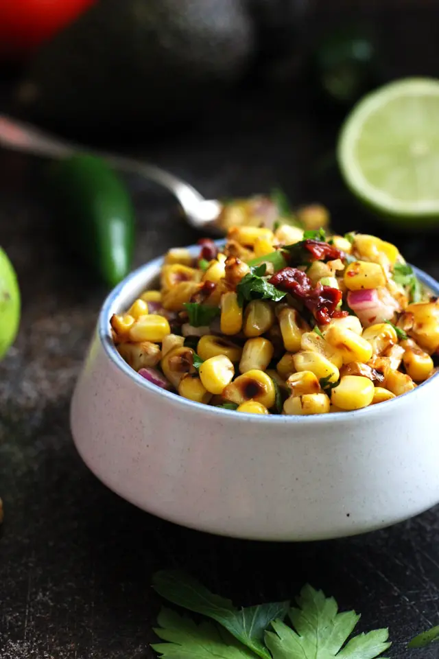 Chipotle corn salsa in a white bowl on a dark table