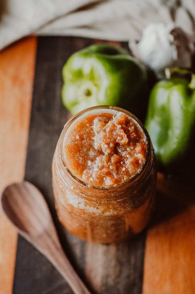 spicy fermented bell pepper salsa in a jar on a wood table