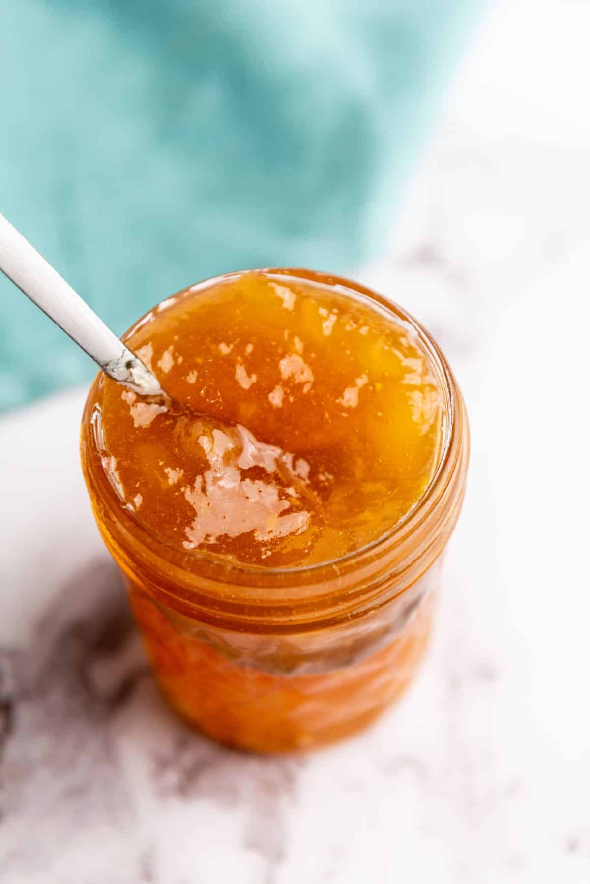 overhead closeup of orange jam on a white table