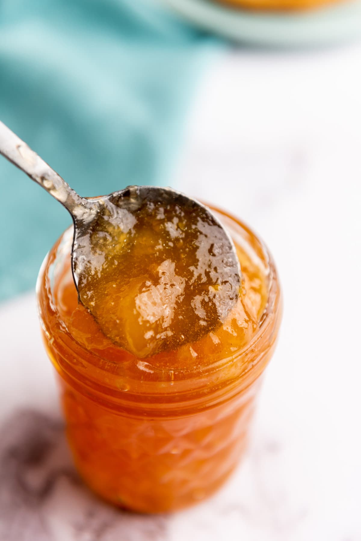 a closeup of a spoonful of orange jam sitting on a table