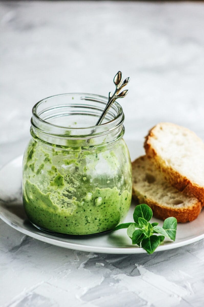 green sauce on a white plate and marble table