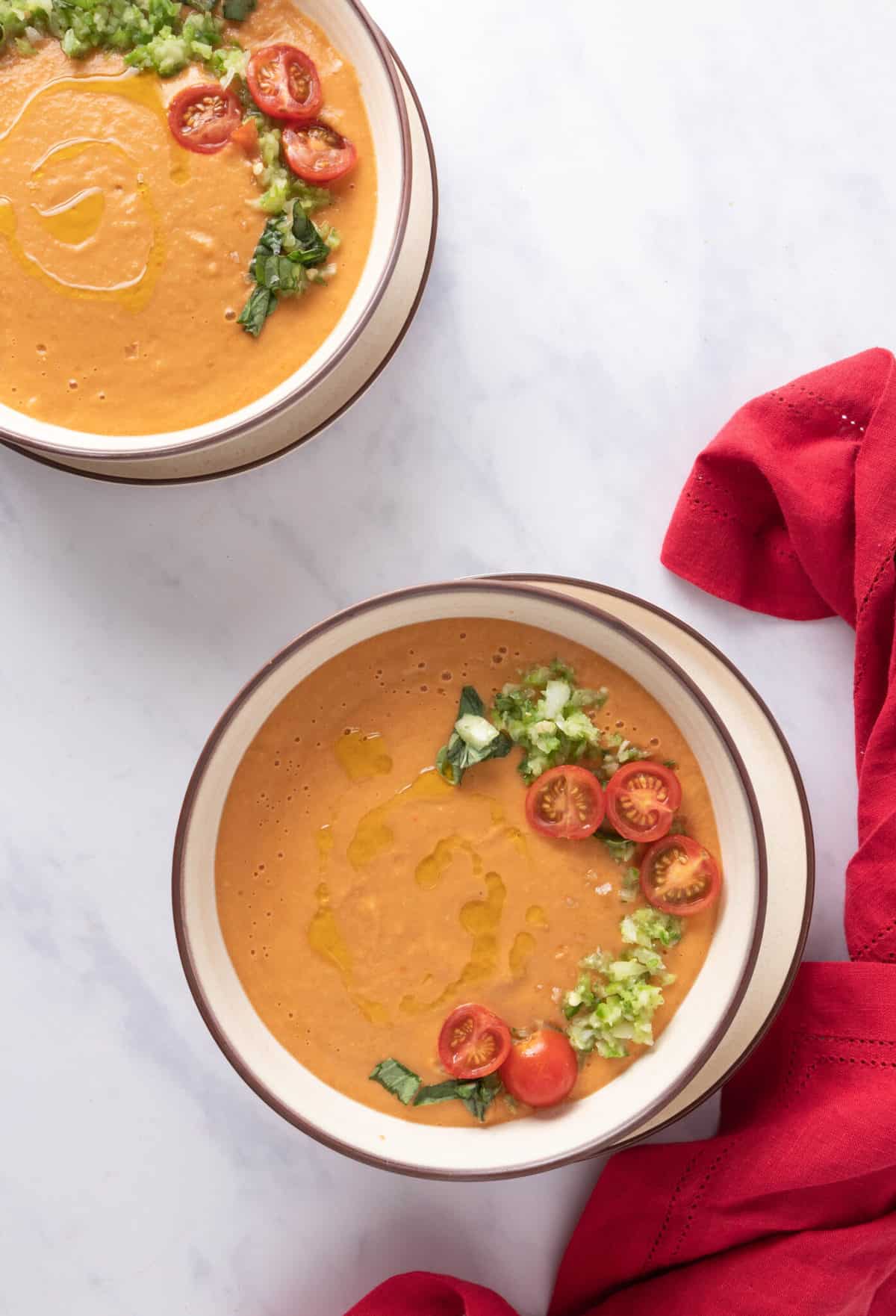 2 bowls of summer gazpacho soup on a white table