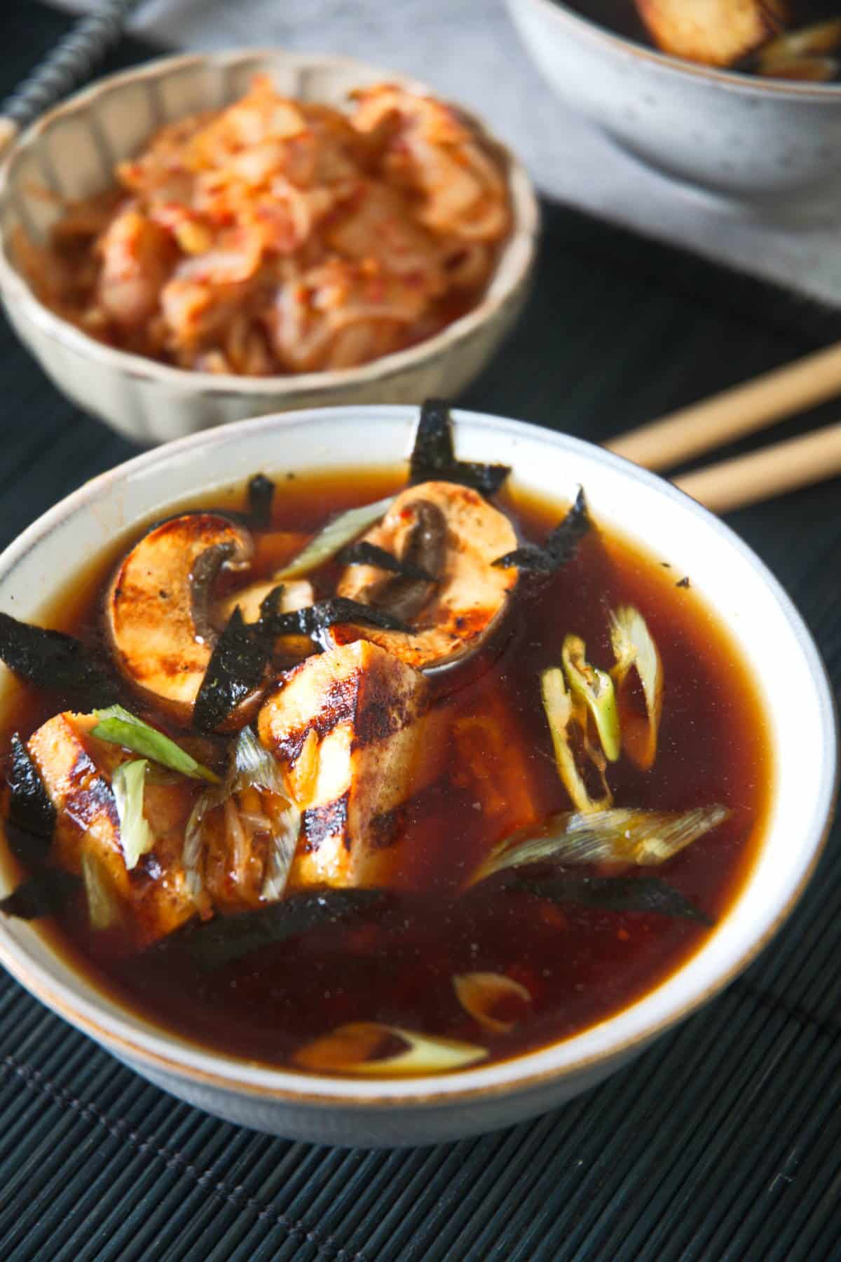 big bowl kimchi tofu soup on a dark mat