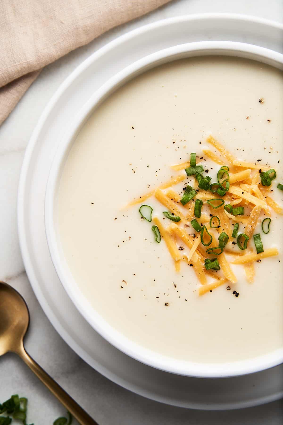 vegan potato soup in a white bowl on a white table