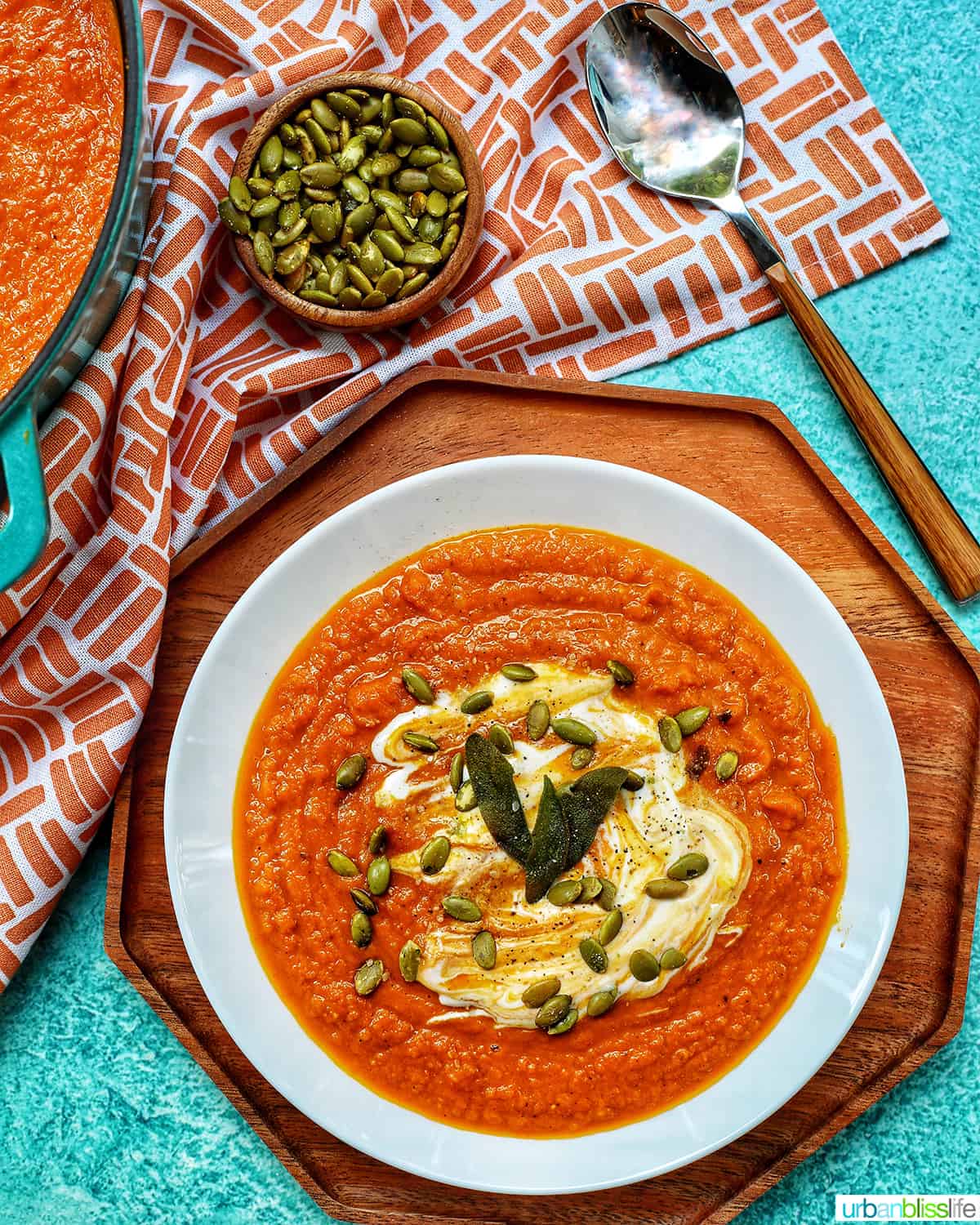 a white bowl of pumpkin soup on a colorful background