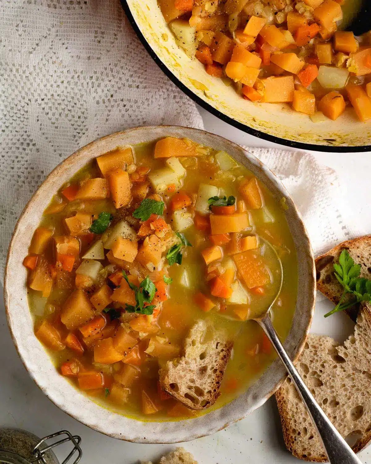 2 bowls of swede and carrot soup on a lace tablecloth