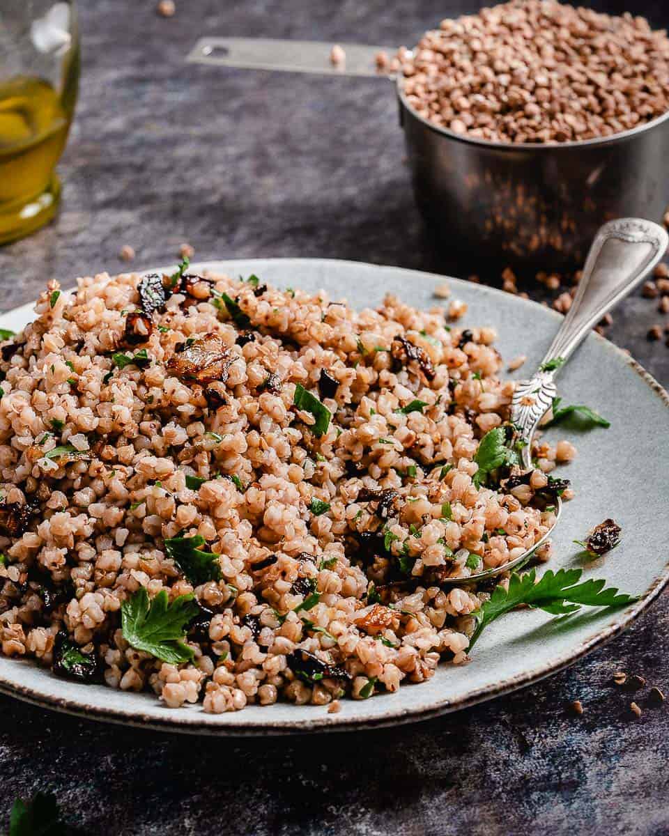 a white plate full of buckwheat with fried onions