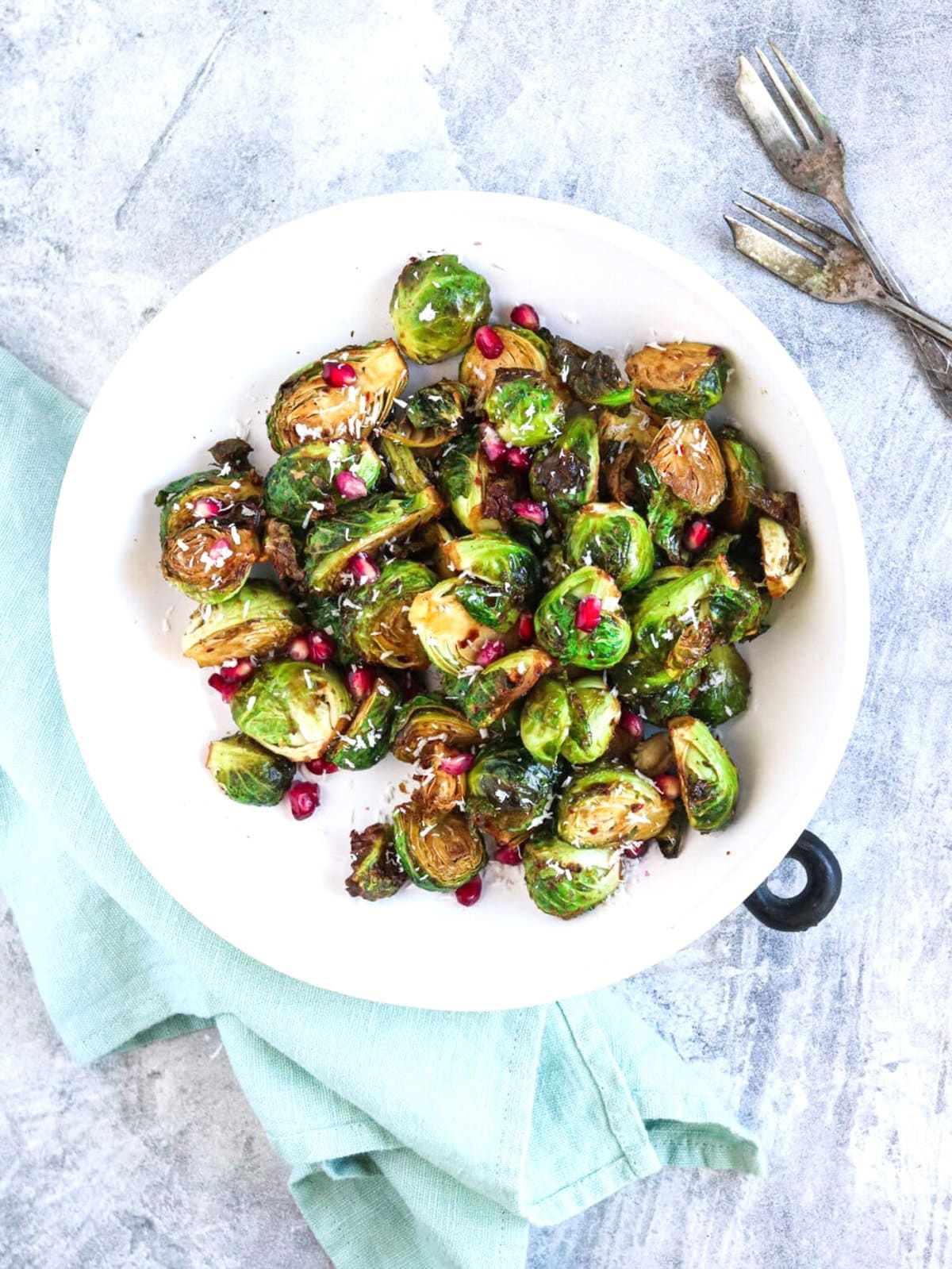 overhead view of brussel sprouts on a white plate and gray table