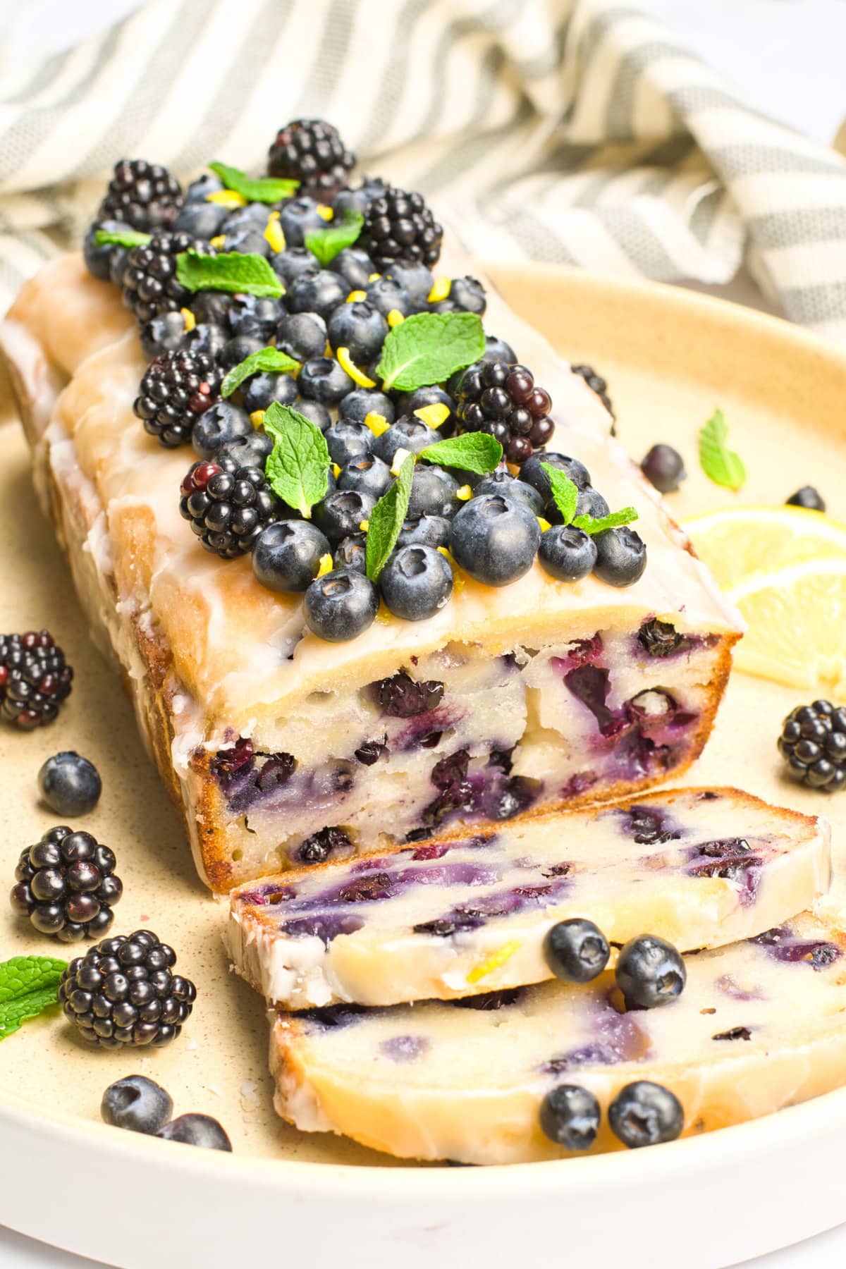 a lemon blueberry loaf with no eggs or dairy on a white plate