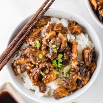 overhead view of sticky shiitake mushrooms in a white dish