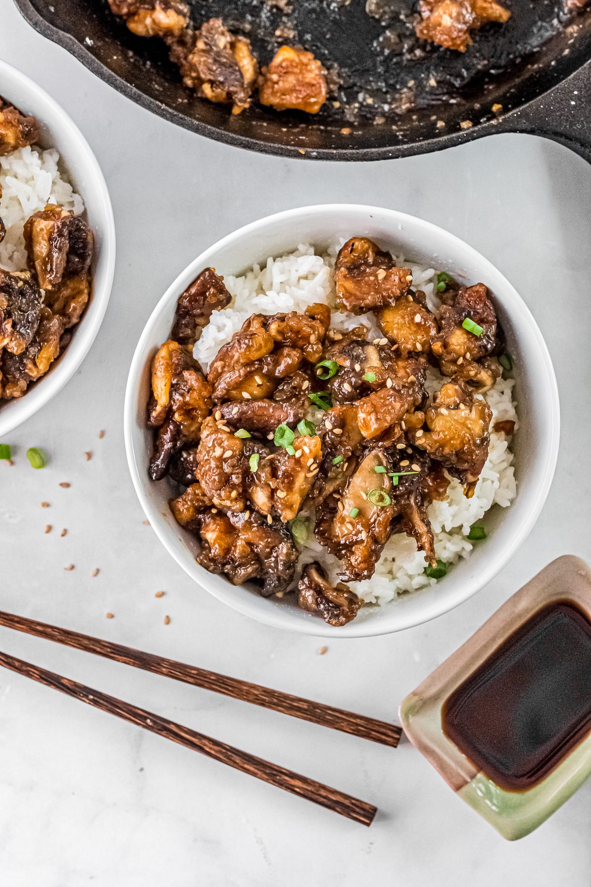 sticky shiitake mushrooms in a white bowl full of rice