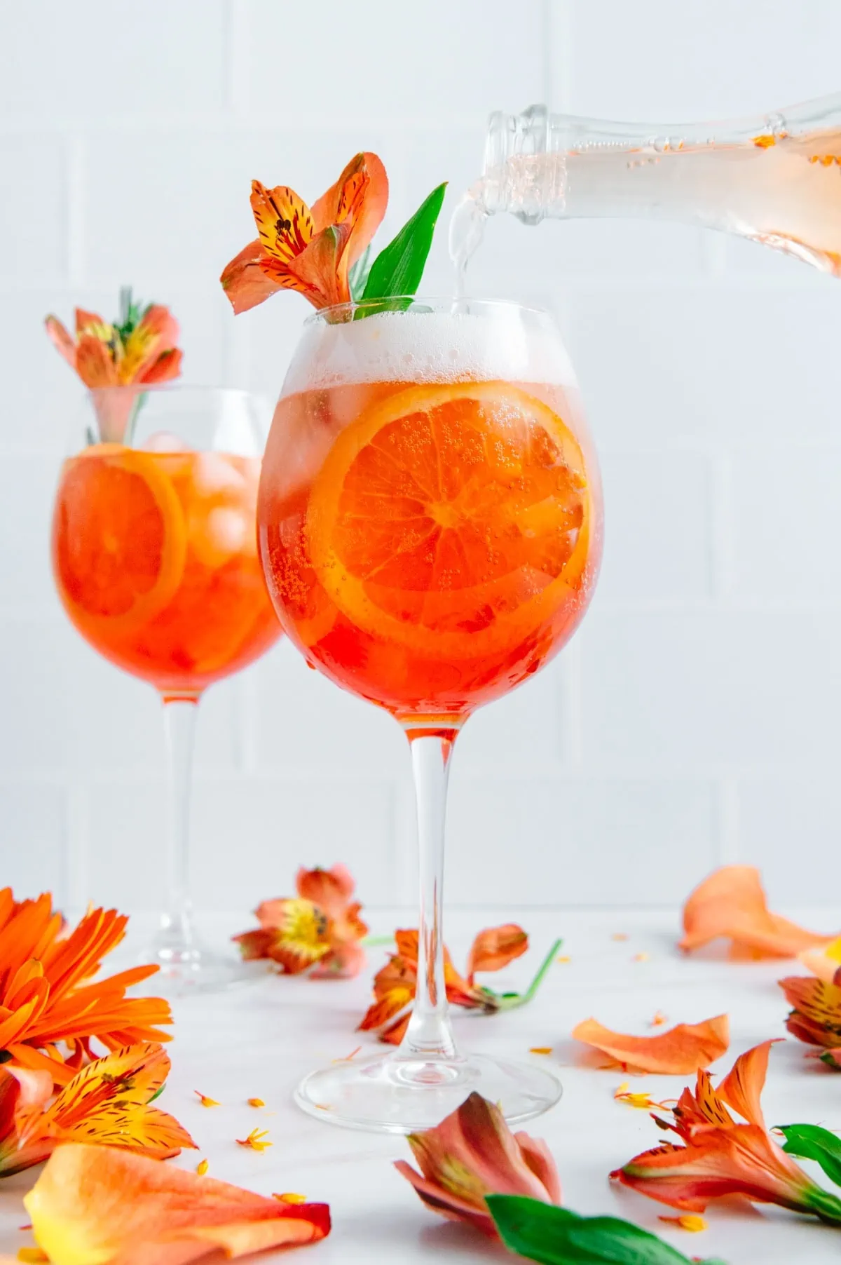2 glasses of Aperol Spritz on a white table