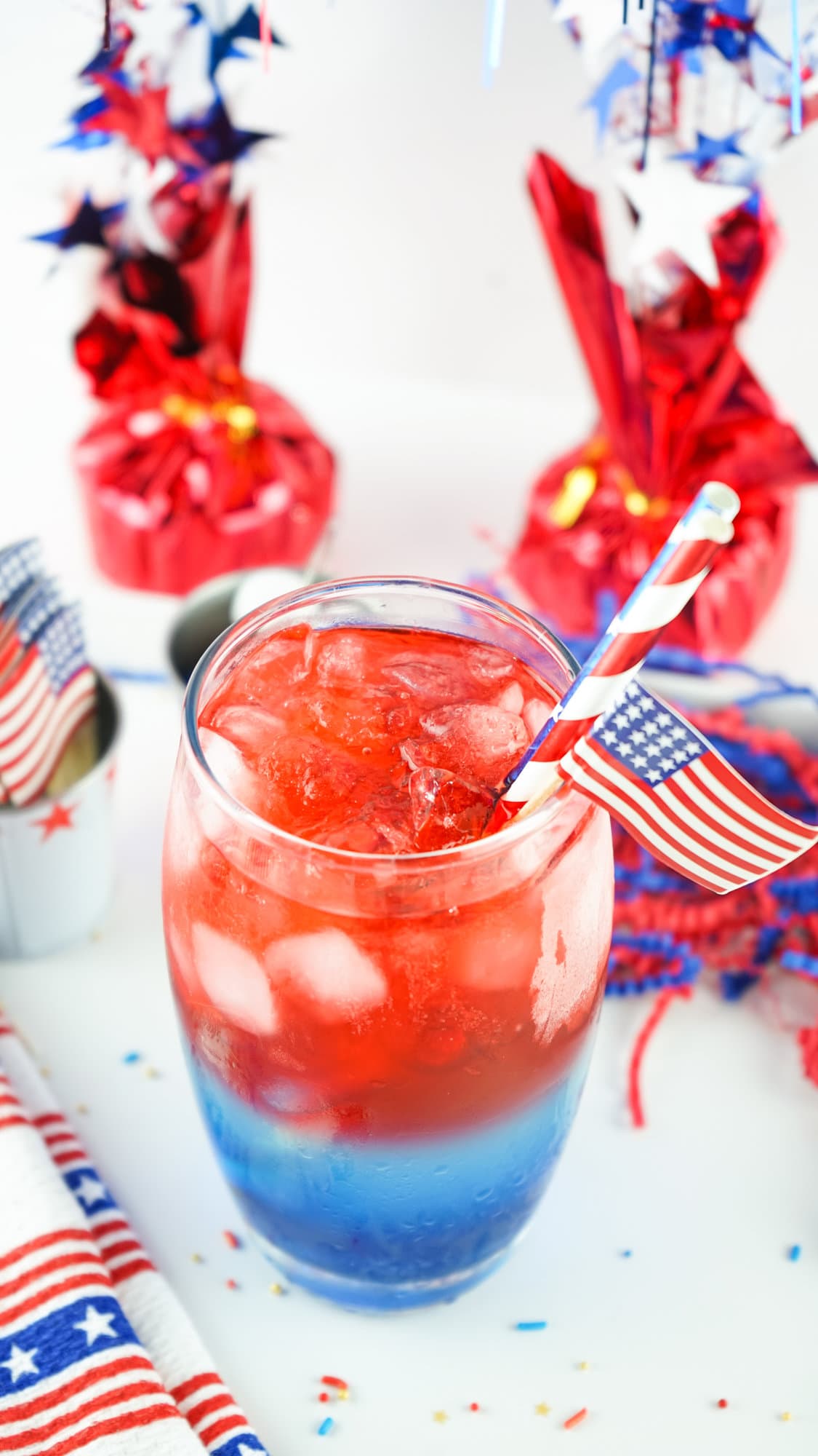 red white and blue cocktail with festive straws and flag