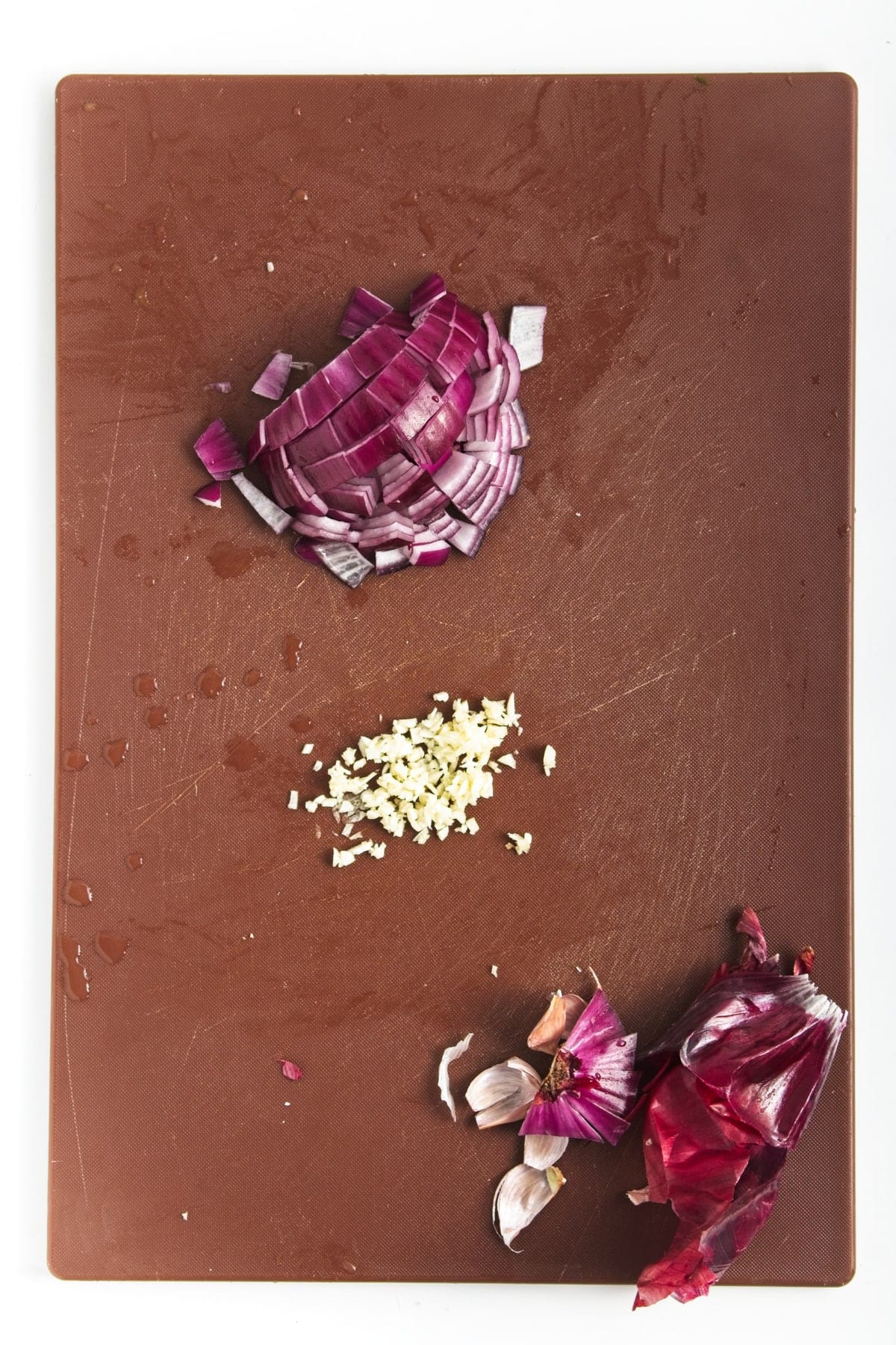 chopped red onion on a brown cutting board