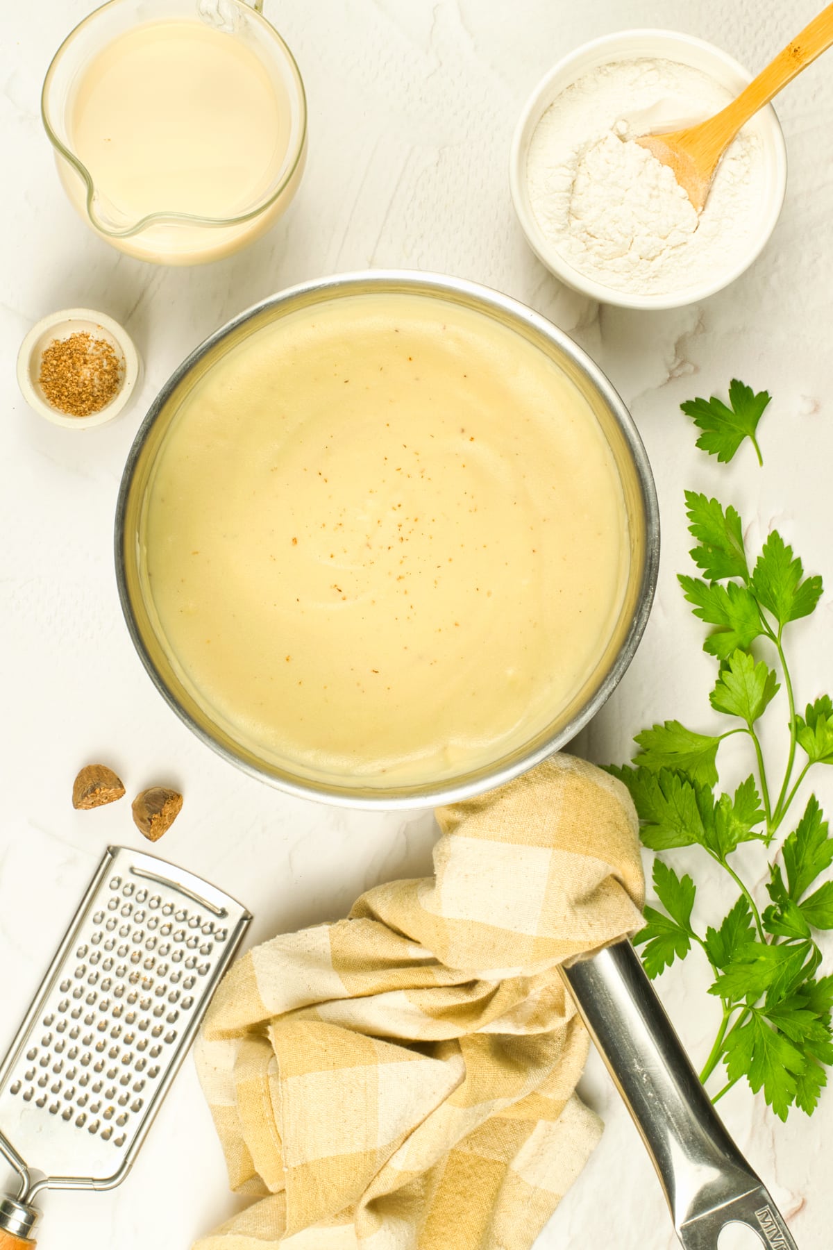 overhead view of vegan béchamel sauce in a pan on a white table