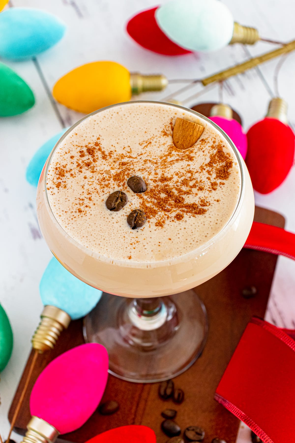 closeup overhead view of eggnog espresso martini with coffee beans and cinnamon
